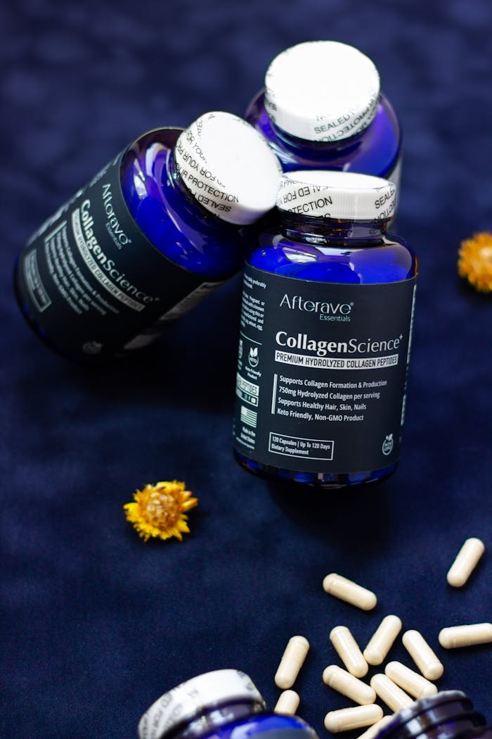 CollagenScience supplement bottles and capsules on dark background with flowers.